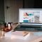turned on Acer laptop on table near cup swollen macbook, trackpad popping, damaged laptop