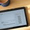 a tablet computer sitting on top of a wooden table freshbooks dashboard, invoicing software, digital agency tools