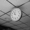 A clock hanging from the ceiling of a room office desk clock punctual workers