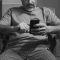 A man sitting in a chair looking at his cell phone person scrolling smartphone,tiktok app,short attention span