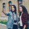 Two friends take a selfie together on a street. teenagers smartphones social media