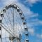 A white ferris wheel against a blue sky. data analytics, prize wheel strategy, user behavior