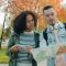 Couple looking at map in park during autumn delivery driver, smartphone navigation, city map route, courier van