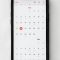 a phone with a calendar on the screen online calendar interface, appointment booking screen, modern scheduling app